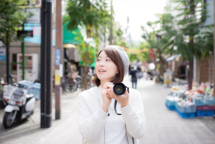旅先で写真撮影を楽しむ女性イメージ
